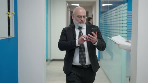 Portrait of Concentrated Focused Serious Caucasian Middle Aged Man Walking in Office Hallway with