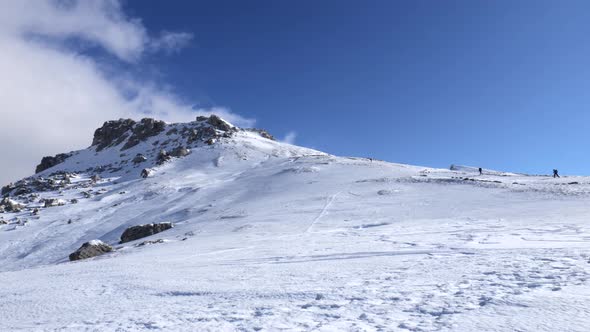 Mountaineers walking, hiking on a winter sunny day to reach the mountain peak