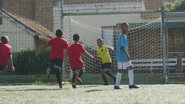 Soccer kids in red smiling and cheering up in a sunny day