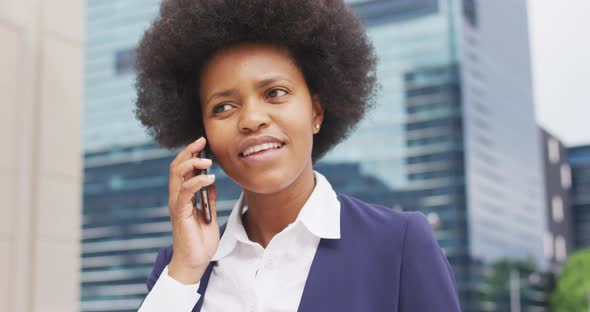 Smiling african american businesswoman talking on smartphone