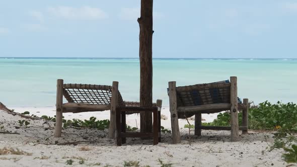 Tropical Deck Chairs Under Beach Umbrella at Sandy Coast By Ocean Zanzibar