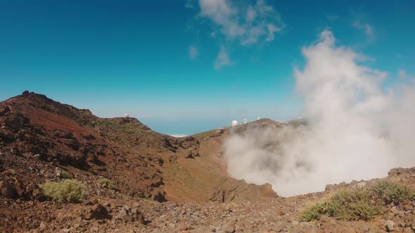 View of a volcanic landscape with the clear blue sky in the background - dust rise up from the crate