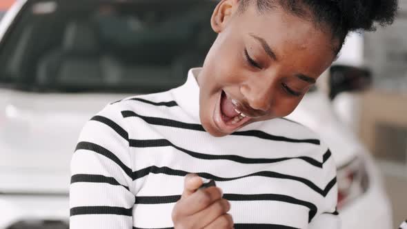 Attractive Young Woman is Getting New Car at Car Dealership