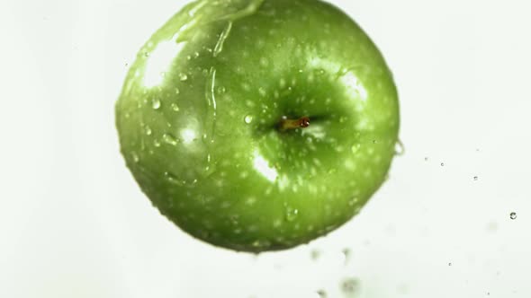 Flying of Green Apple in White Kitchen Background in Slow Motion