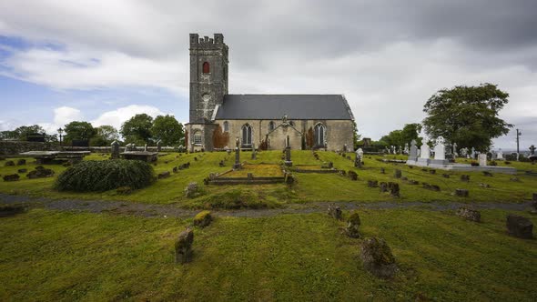 Time lapse of historical cemetery and medieval church in rural Ireland with passing clouds and sunsh