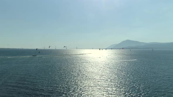 Aerial view faraway of group kitesurfing at Gulf of Patras, Greece.