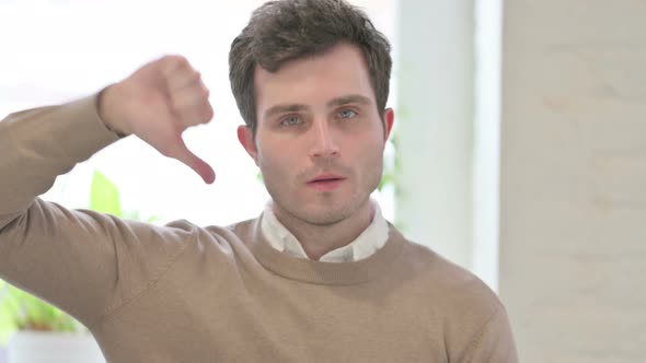 Portrait of Man Showing Thumbs Down Gesture