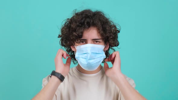 Curly Haired Man Puts a Mask on His Face From Air Pollution and Coronavirus