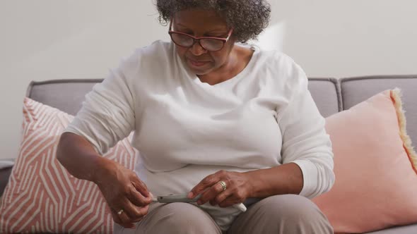 Senior mixed race woman using a smartphone. Social distancing and self isolation in quarantine