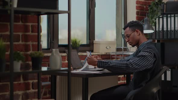 African American Person Analyzing Financial Statistics on Laptop