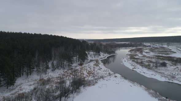 Aerial view of winter river near the forest and fields, Mainly cloudy