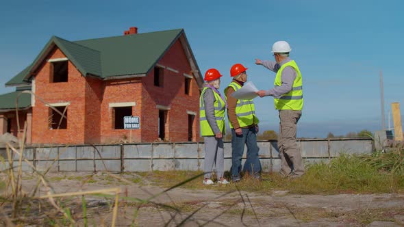 Architect with Senior Civil Engineers Discussing Project Work with Blueprint of Building House