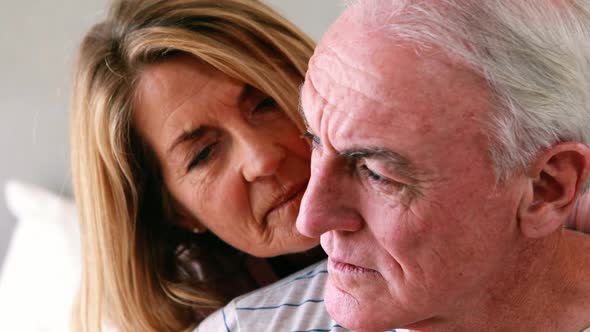 Happy senior couple interacting with each other on bed