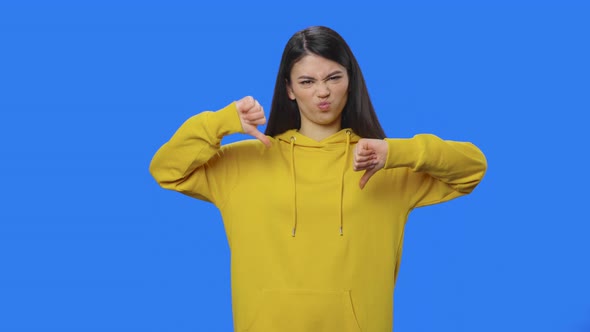 Portrait of Pretty Brunette Showing Thumbs Down Gesture