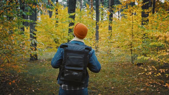 Young Male Backpacker Enjoying Bright Colors of Autumn Forest 360 Degree Tracking Arc Shot