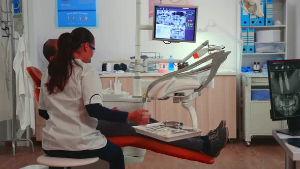 Doctor Examining Teeth with Medical Instruments