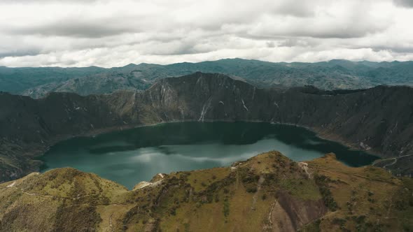 Aerial panorama view showing volcano landscape with calm blue colored crater lake in Andes