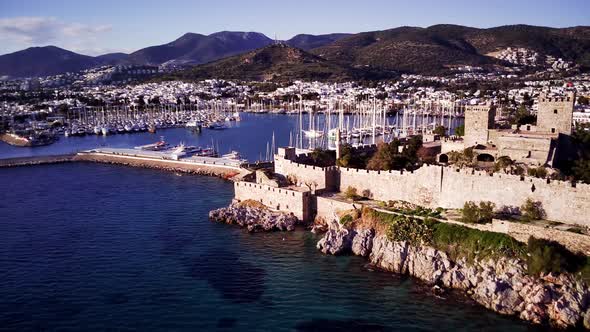 View from drone on full of yachts Bodrum harbour and ancient Kalesi castle in Mugla in Turkey