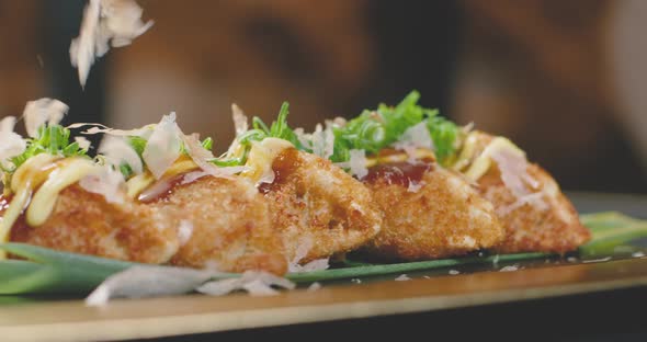 Anonymous cook spilling katsuobushi on delicious gyozas