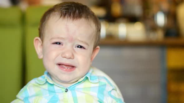 Mother Gives Baby Food From a Baby Spoon in a Restaurant, a Child Eats Willingly