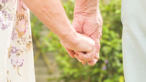 Elderly couple holding hands