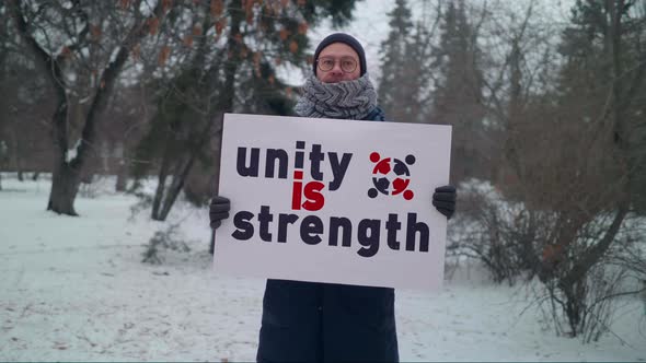 An Activist is Carrying a Placard Unity is Strength for people to get together