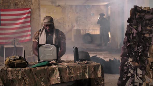 US Soldier Using Laptop, Radio at Makeshift Base