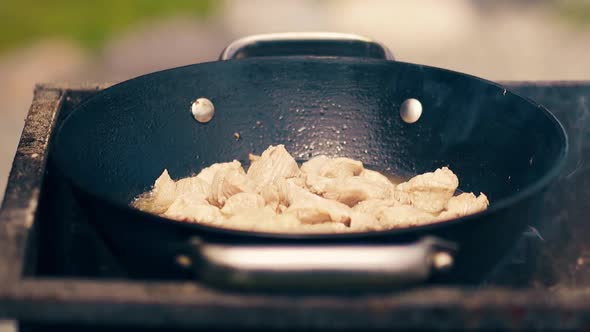 Close-up, Slow Motion: Meat Is Roasted in a Cauldron, on Coals, on a Brazier, in Oil