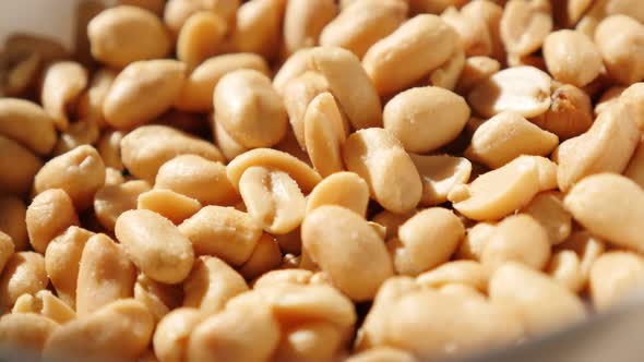 Bowl full of groundnut snack food slow tilting background 4K 2160p UltraHD video - Salted and roaste