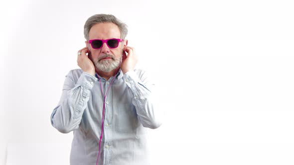 Caucasian Senior Wearing the Pink Sunglasses and Earphones  Dancing Isolated on White Background