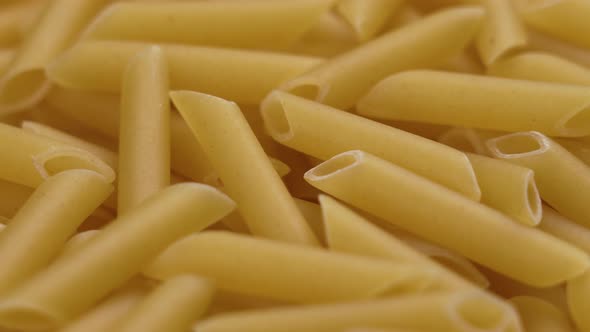 Uncooked Italian wheat penne pasta close-up. Mediterranean cuisine