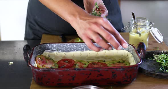 Woman preparing vegetable casserole in kitchen