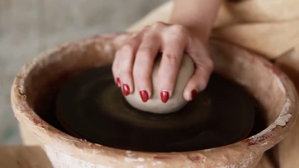 A Close Up of Hands Working on a Ceramic Piece on a Pottery Wheel in a Clay Studio