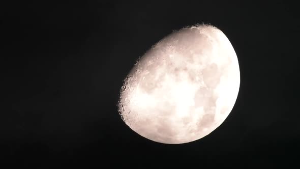 Close up shot of clouds passing in front of the moon.