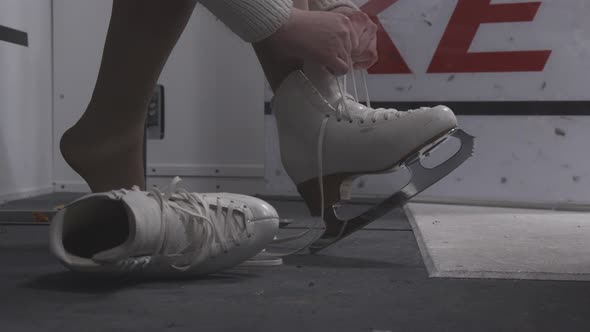 Ice Skater Putting On White Skates