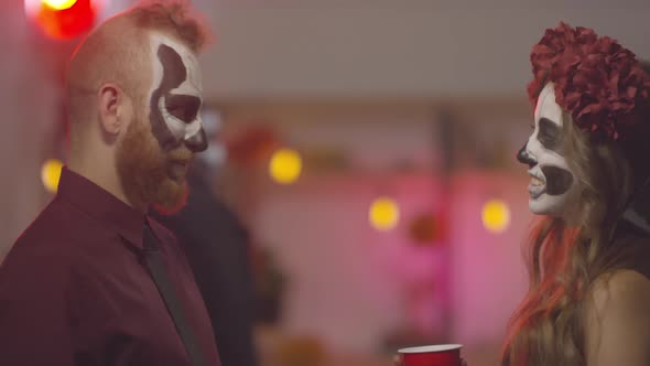 Cheerful Man and Woman Chatting at Halloween Party