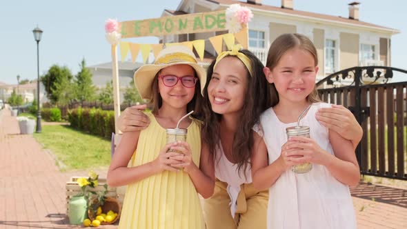 Cheerful Mom And Daughters With Lemonade Outdoors