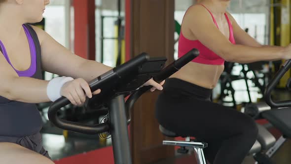Hardy Girl with Curvy Body Working out In Gym, Banishing Fat on Stationary Bike