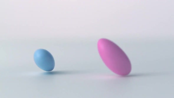 Slow-motion pastel almonds dropping and spinning