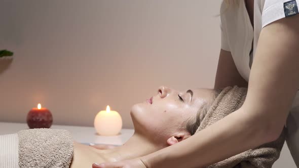 Relaxing massage. Woman receiving head massage at spa salon, side view.