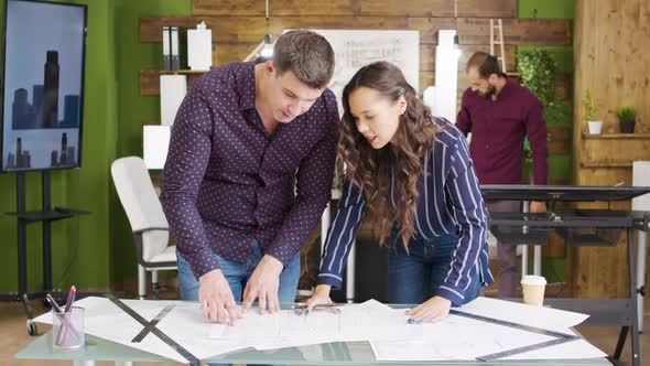 Female Architect Taking a Sip of Coffee and Working on Blueprints