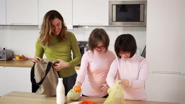 Down Syndrome Girls with Mother on Kitchen After Shopping Slow Motion