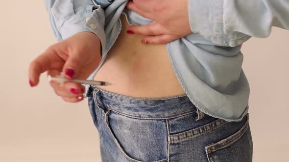 Closeup of a Woman Makes a Shot of Insulin in the Fat Fold on the Stomach