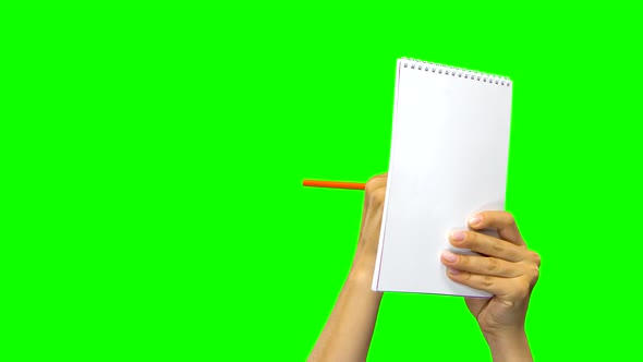 Hands Writing Down Something in Notebook. Green Screen. Close Up.