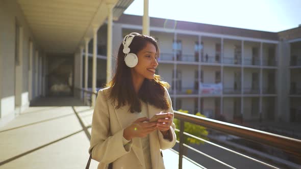 Slow motion shot of Indian woman with smartphone and headphones