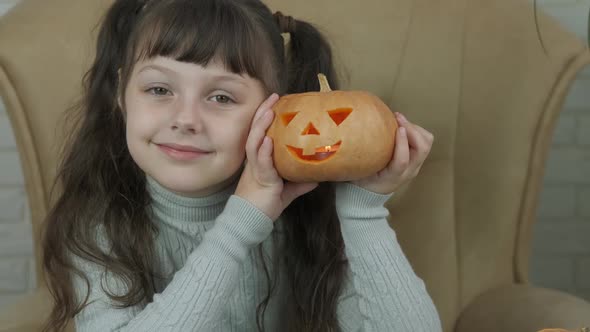 Child with a carved pumpkin.