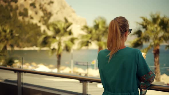 Woman Relaxing And Drinking Coffee On Cafe Near Sea.Girl Drinking  Tea And Looking On Sea.