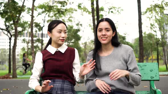 Two Female Women Friends Talking at Public Park and Raising Hands Together