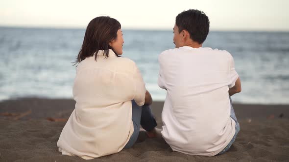 Couple sitting on the beach and having a conversation
