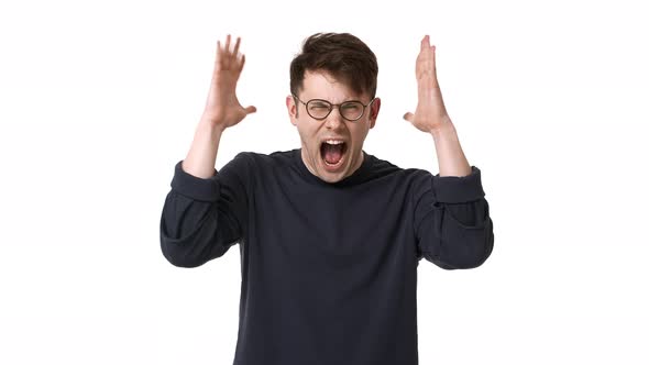 Portrait of Irritated Man Wearing Black Sweatshirt and Eyeglasses Gesturing Hands Up and Shouting in